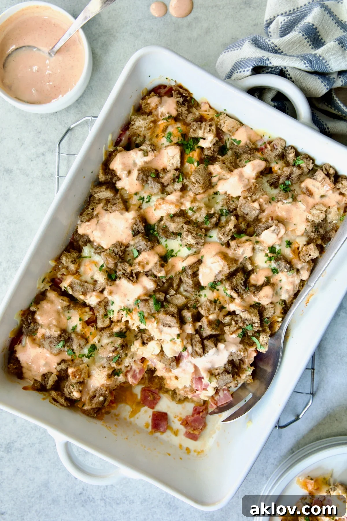 Creamy Reuben Comfort Casserole 2 A golden-brown Reuben Casserole in a white rectangular baking dish, resting on a cooling rack, ready to be served.