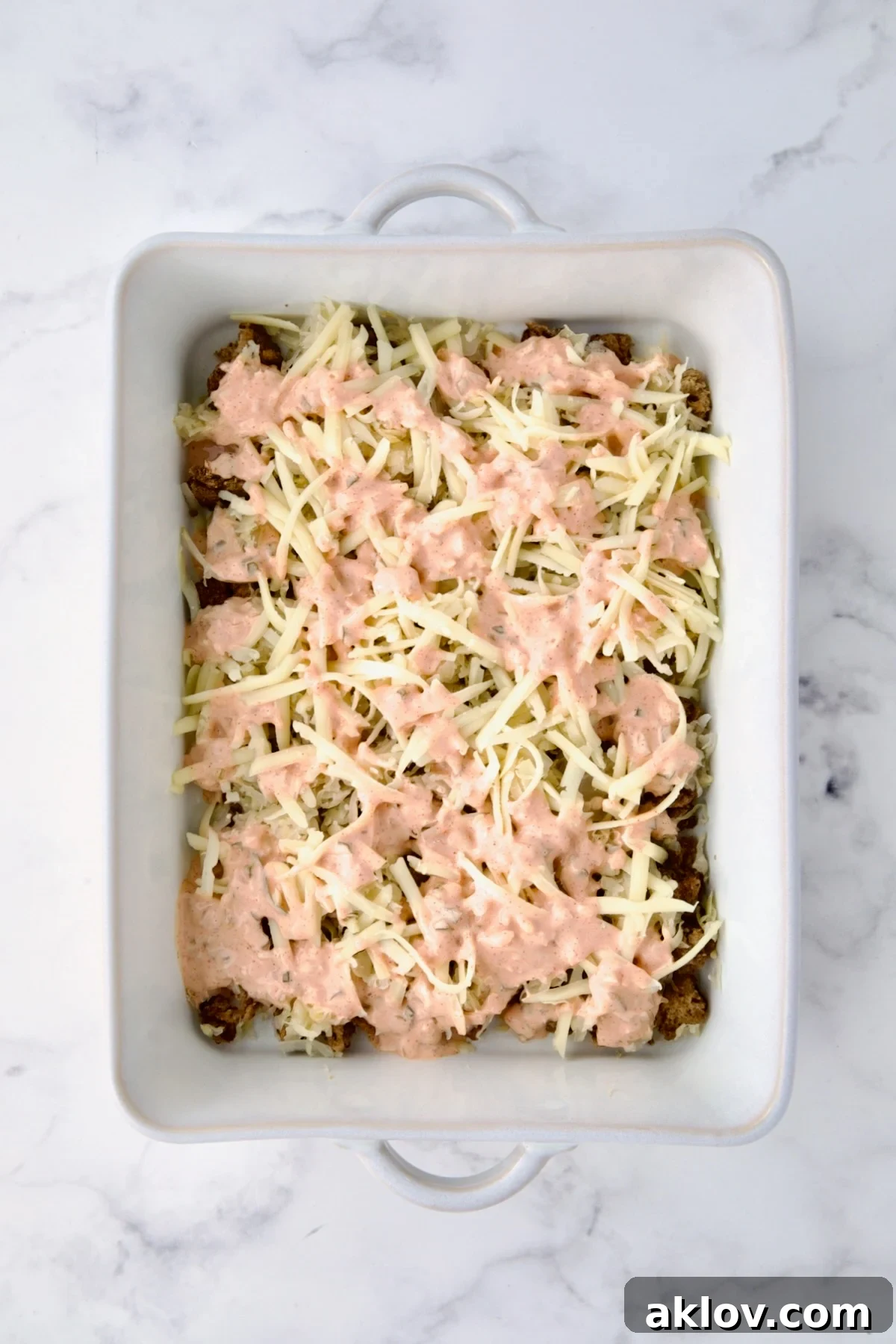 Creamy Reuben Comfort Casserole 11 Creamy Thousand Island dressing artfully drizzled over the layers of rye bread cubes, sauerkraut, and Swiss cheese in the white baking dish.