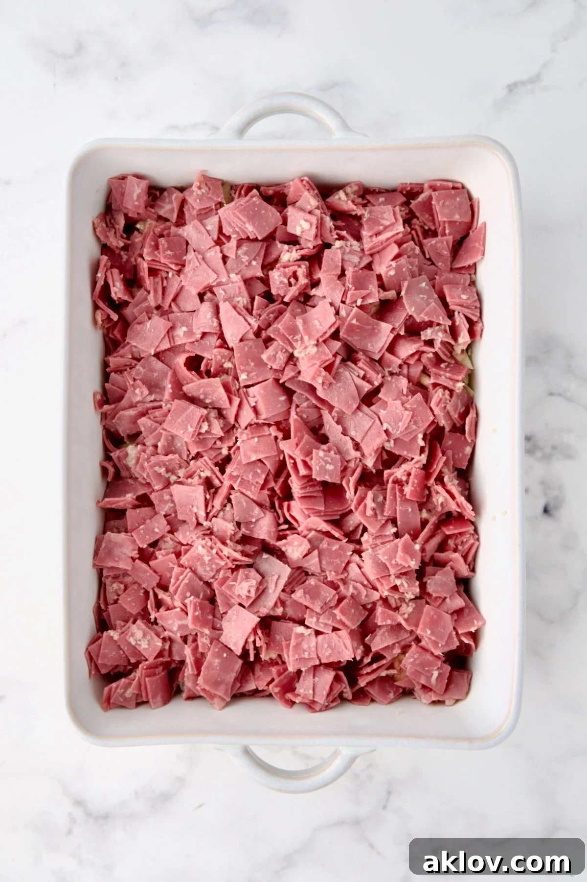 Creamy Reuben Comfort Casserole 12 Generous layer of seasoned corned beef expertly placed over the previous layers in the white baking dish.