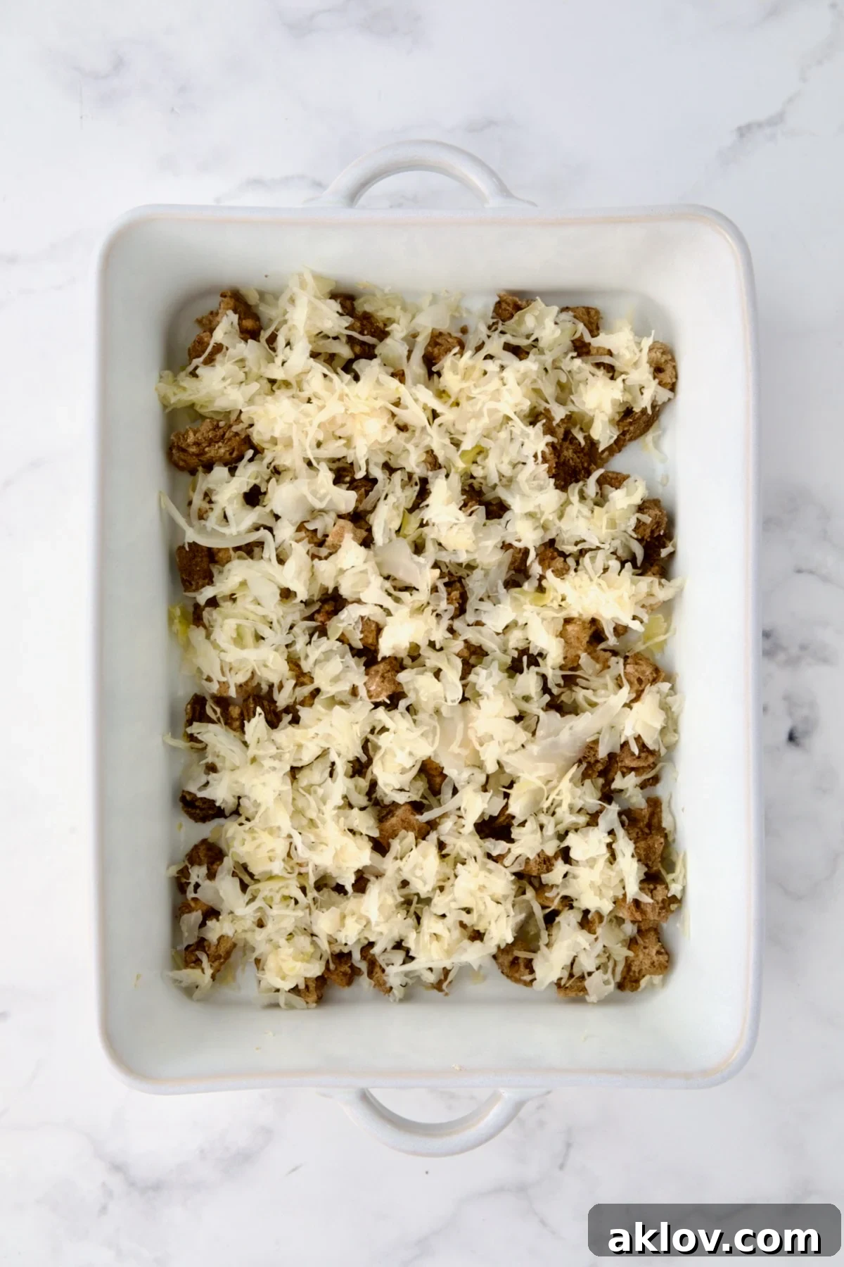 Creamy Reuben Comfort Casserole 9 A layer of tangy sauerkraut evenly spread over the toasted rye bread cubes in the white baking dish.