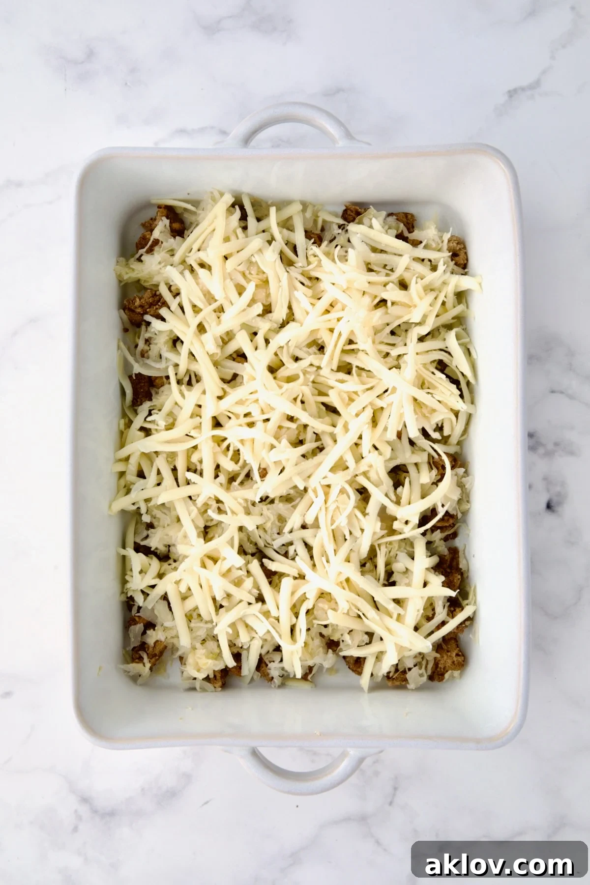 Creamy Reuben Comfort Casserole 10 Shredded Swiss cheese generously layered over the sauerkraut and rye bread cubes in the baking dish.