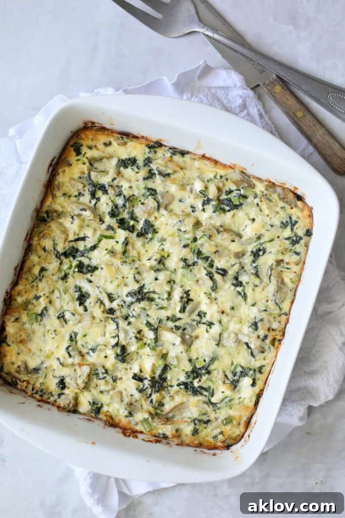 Photo of Spinach Artichoke Squares just out of the oven, before being cut, showcasing their golden-brown top.
