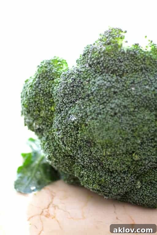 A detailed close-up of fresh, raw broccoli florets, showcasing their intricate structure and healthy green hue.