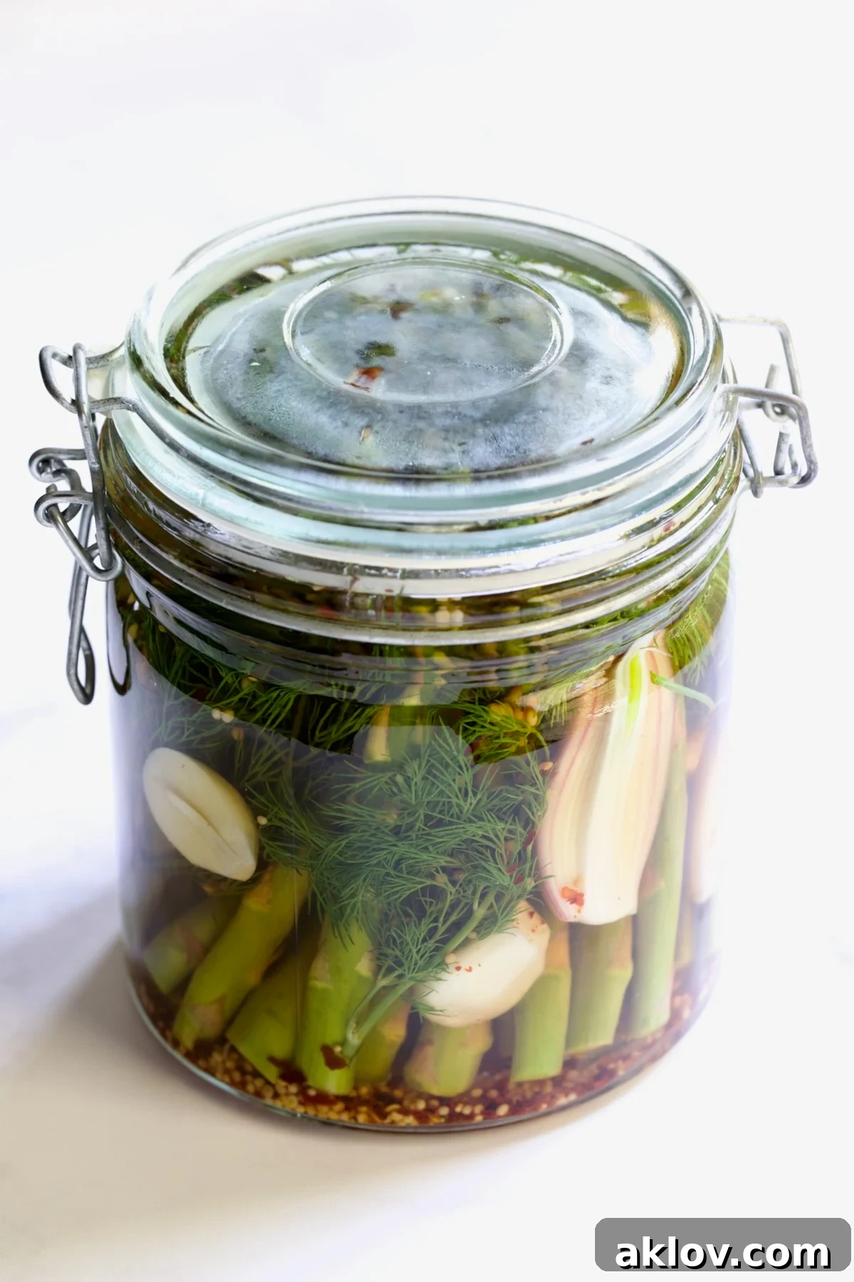 Zesty Pickled Asparagus 9 A glass jar filled with freshly pickled asparagus, securely sealed with a lid and ready for refrigeration.