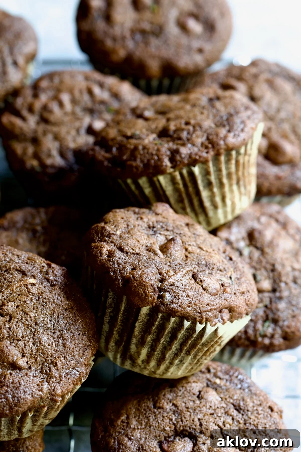 A charming pile of freshly baked Chocolate and Zucchini Muffins, showcasing their rich, dark color and the inviting texture.