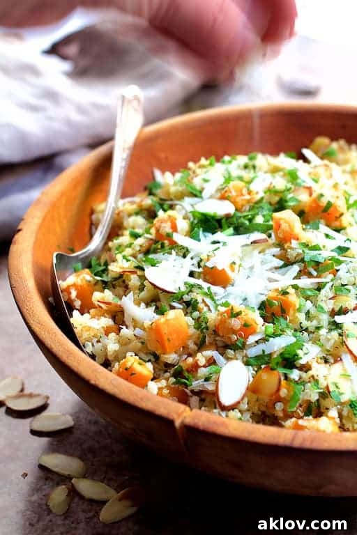Photo of Lemony Quinoa with Roasted Butternut Squash Almonds and Parmesan Cheese being sprinkled with Parmesan cheese.