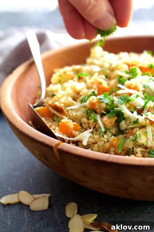 Photo of parsley being sprinkled on Lemony Quinoa with Butternut Squash, Almonds and Parmesan Cheese.