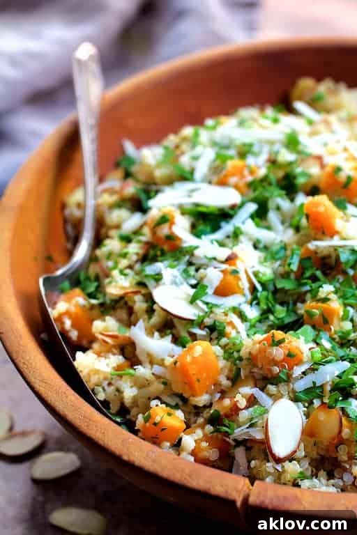 Close-up photo of Lemony Quinoa with Butternut Squash Almonds and Parmesan Cheese - Straight-on close-up shot in wooden bowl with serving spoon.
