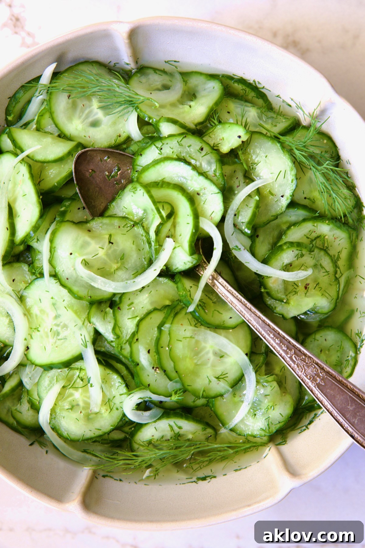 Cucumber Onion Salad in a elegant serving bowl with a spoon, ready for the table.
