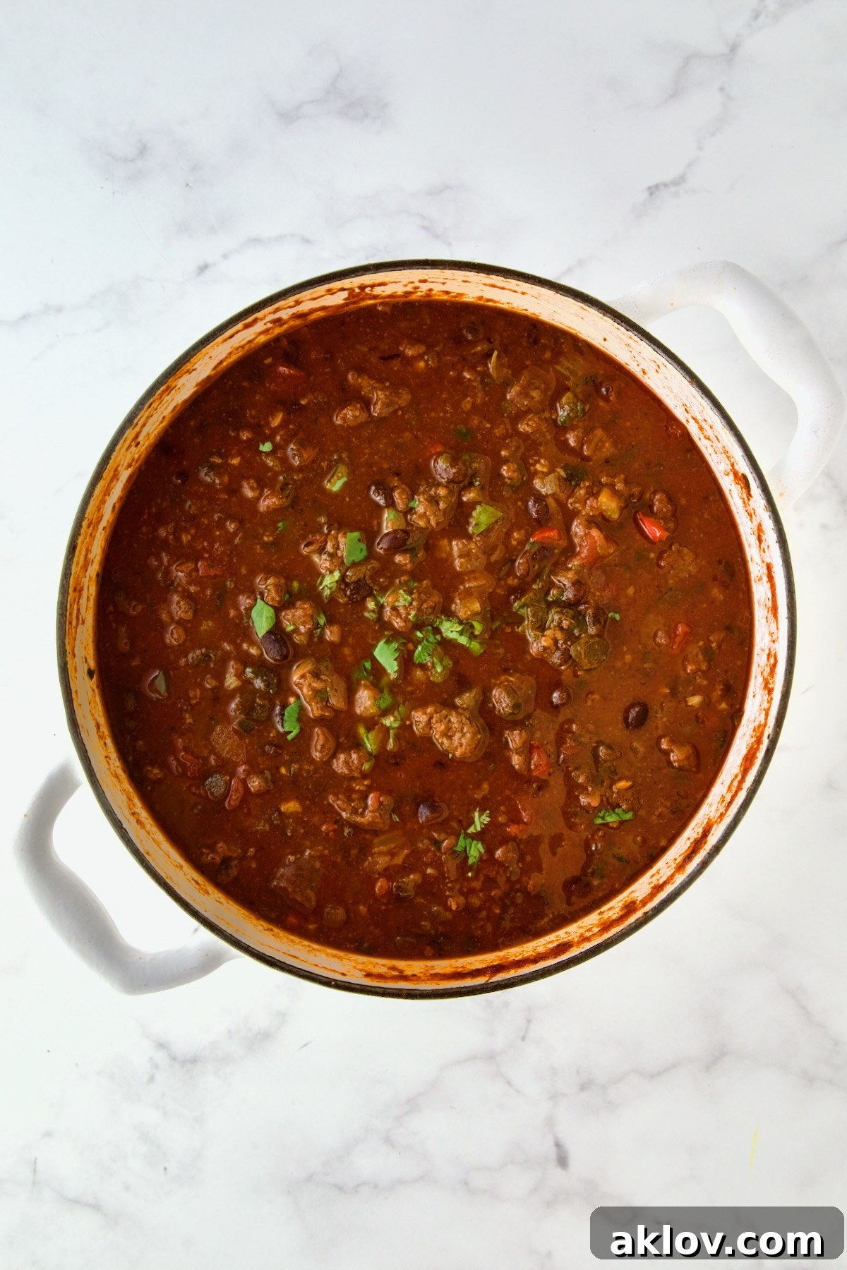 Finished chili in white enamel Dutch oven.