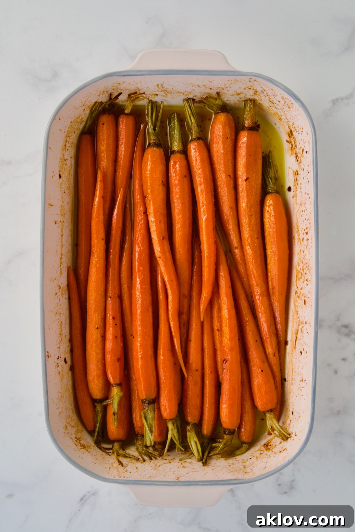 Roasted carrots in white rectangular ceramic baking dish.