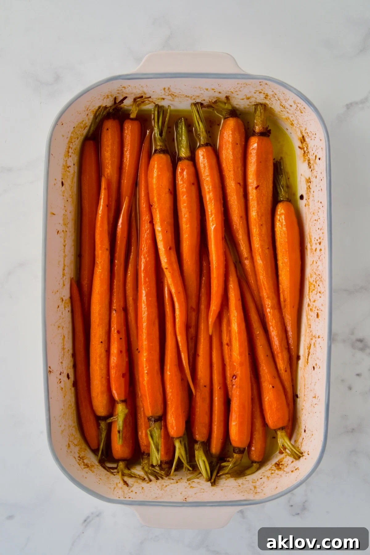 Roasted carrots in white rectangular ceramic baking dish.