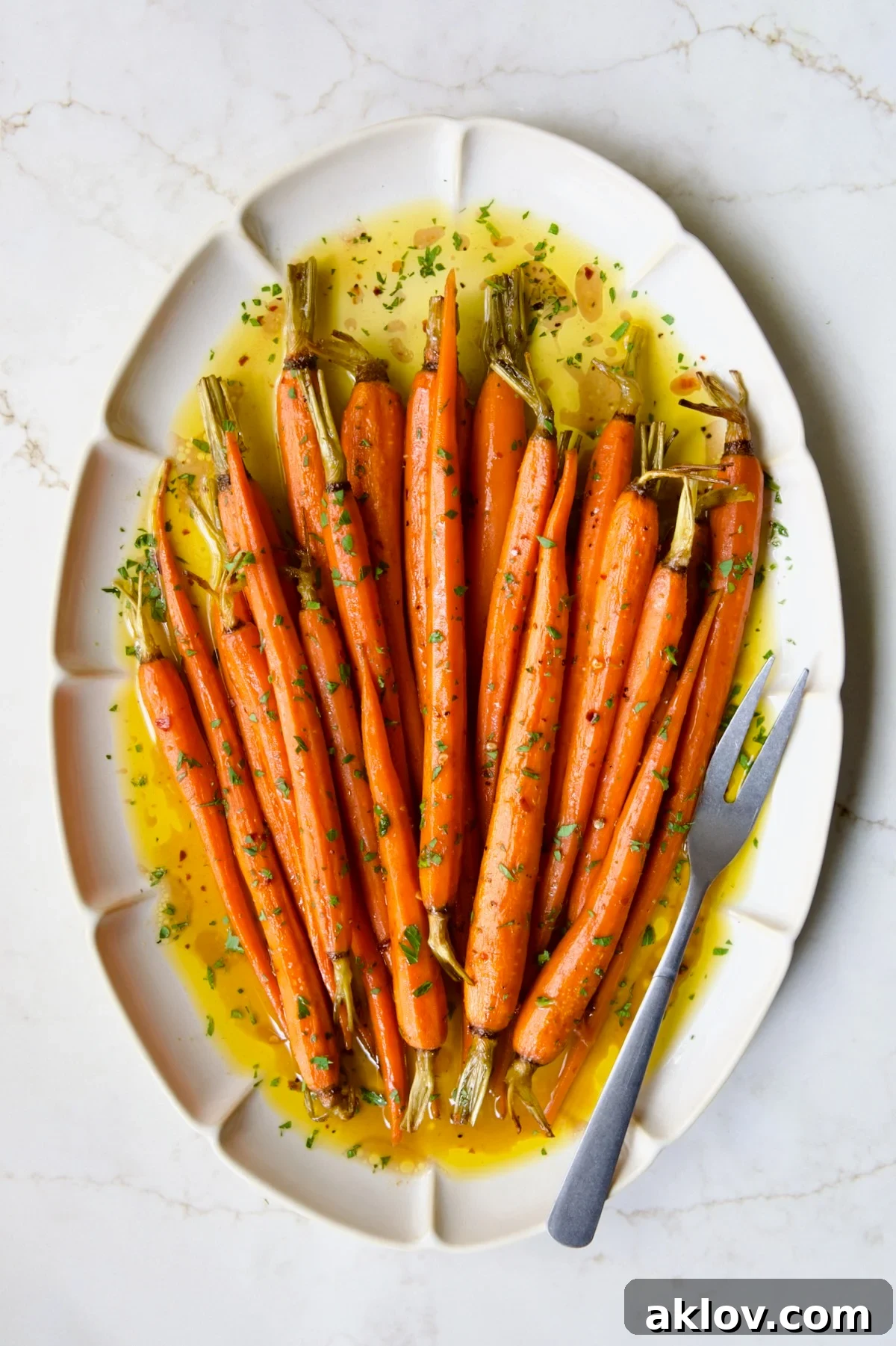 Hot Honey Roasted Carrots on white oval platter with serving fork.