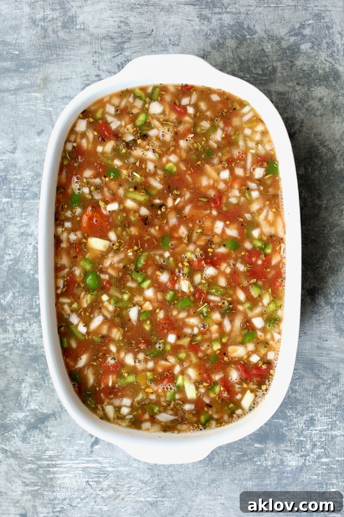 The unbaked Southwestern Lentil and Brown Rice Bake, a colorful mixture of lentils, rice, vegetables, and spices, waiting in an oval white baking dish.