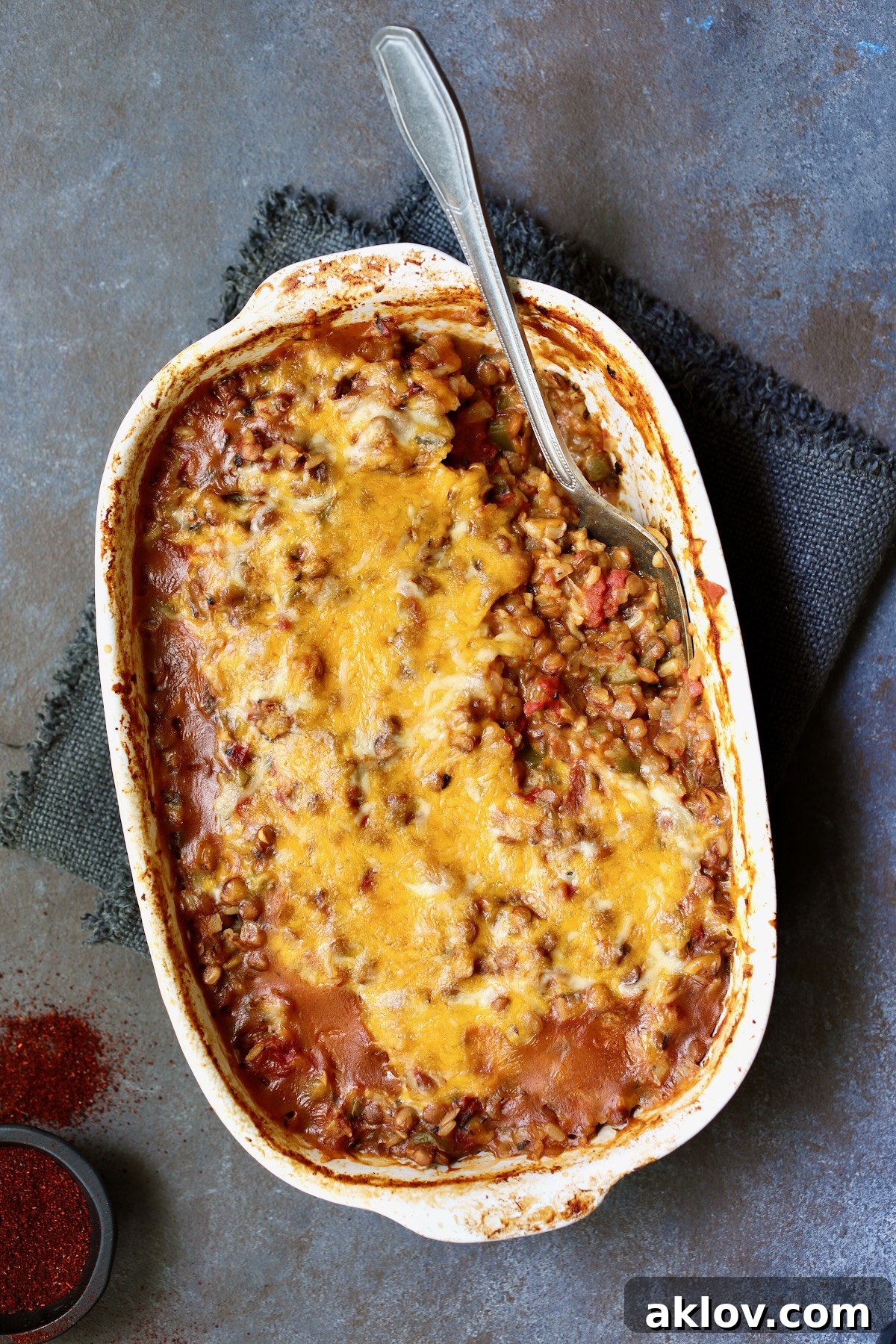 A generous serving of Southwestern Lentil and Brown Rice Bake, scooped into an oval white baking dish, ready to be enjoyed.