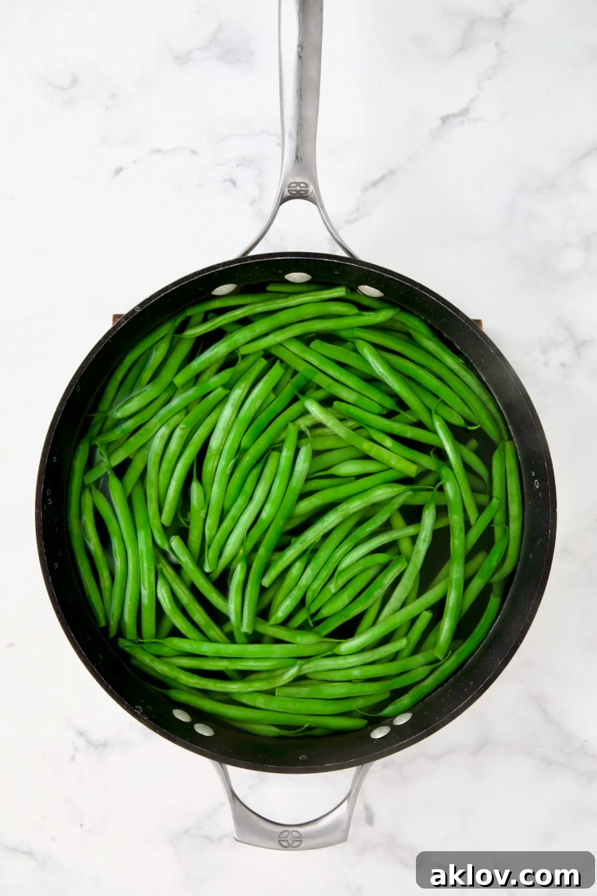 Green beans in water in skillet.