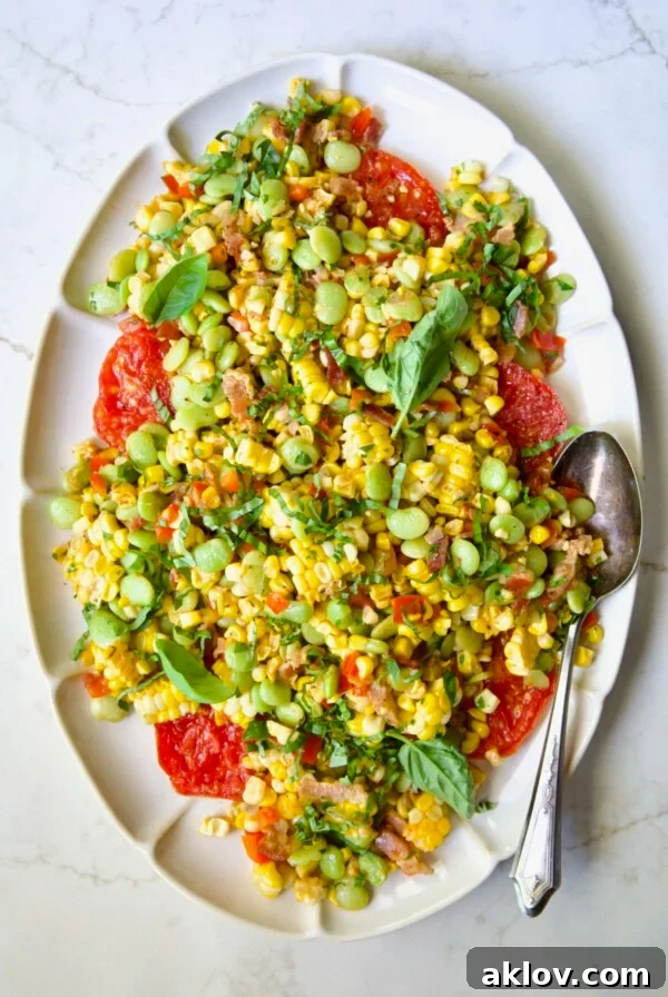 Grilled Corn Succotash on white oval platter garnished with fresh basil leaves.