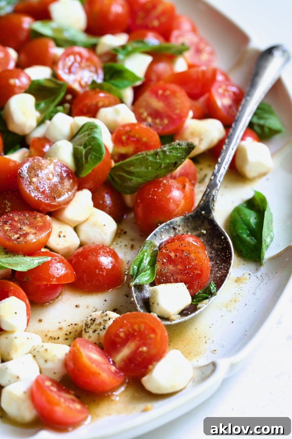 The Caprese Salad with Cherry Tomatoes in its full glory on a white oval platter, inviting diners with its freshness and color.