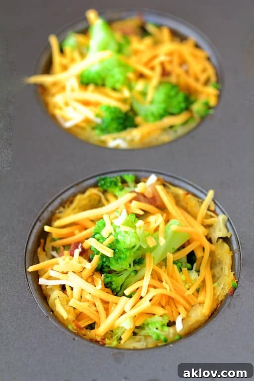 Grab-and-Go Savory Egg Tarts 6 Muffin pan cups filled with a medley of spaghetti squash crusts, broccoli, bacon, cheddar cheese, and the egg mixture, ready for baking.