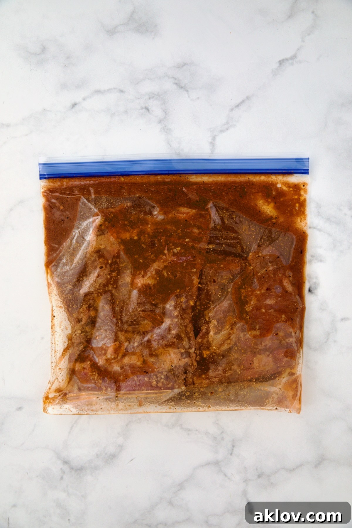 Skirt steak in marinade in gallon-size zipper-top bag.