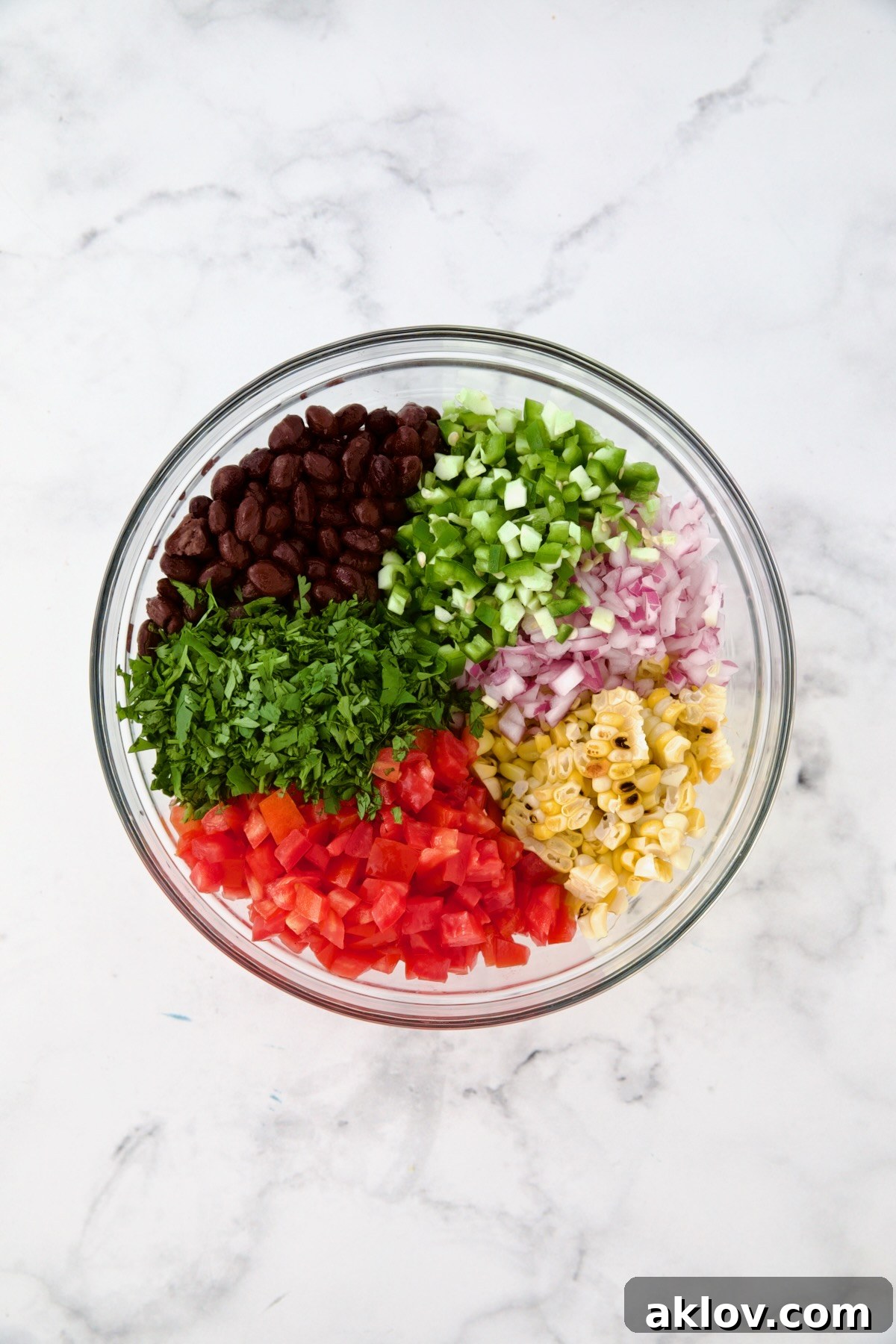 Ingredients for Black Bean Corn Tomato Salad in glass bowl before being combined.