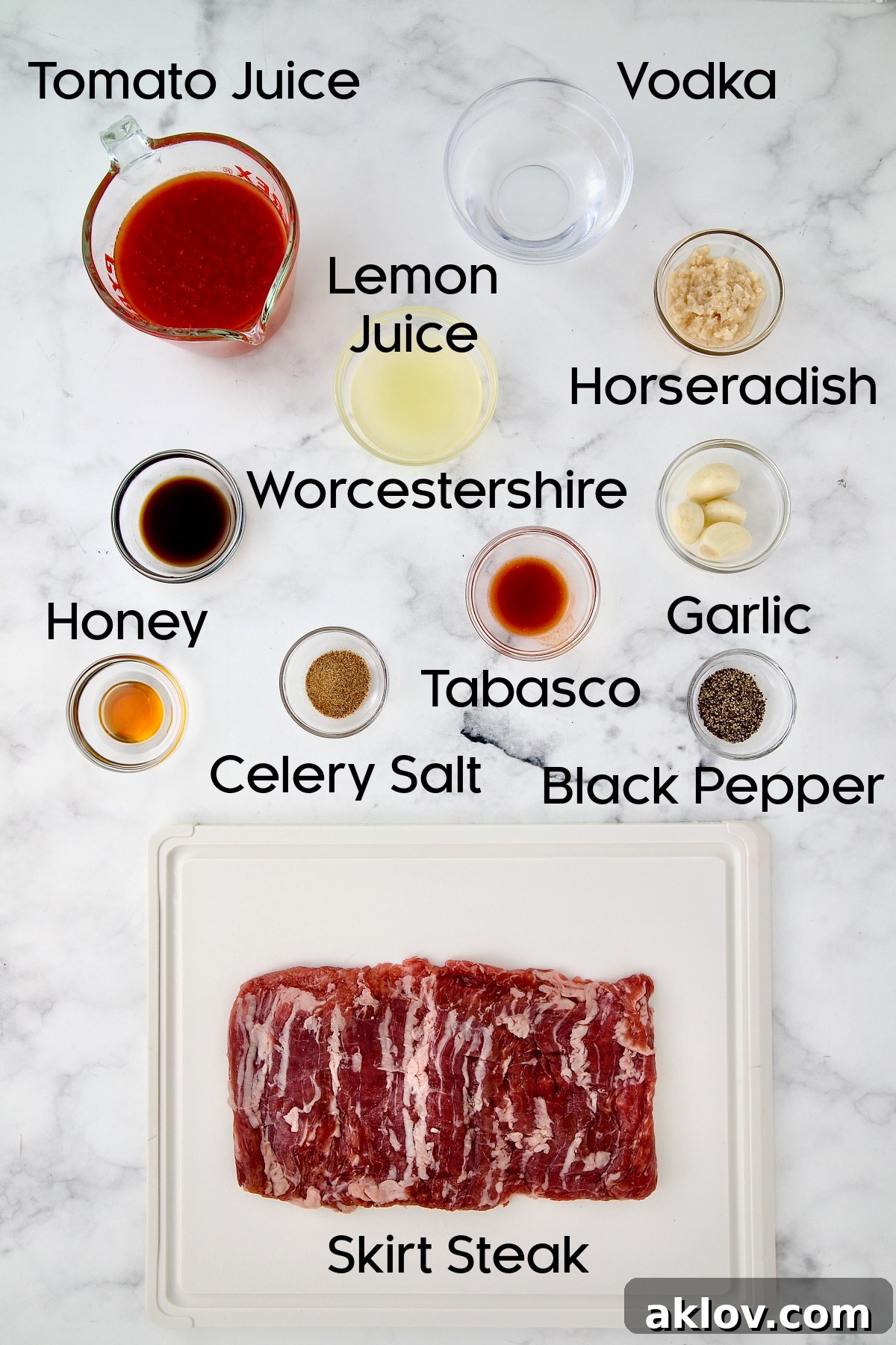 Collection of ingredients for Bloody Mary Skirt Steak, including tomato juice, horseradish, vodka, lemon, garlic, and spices.