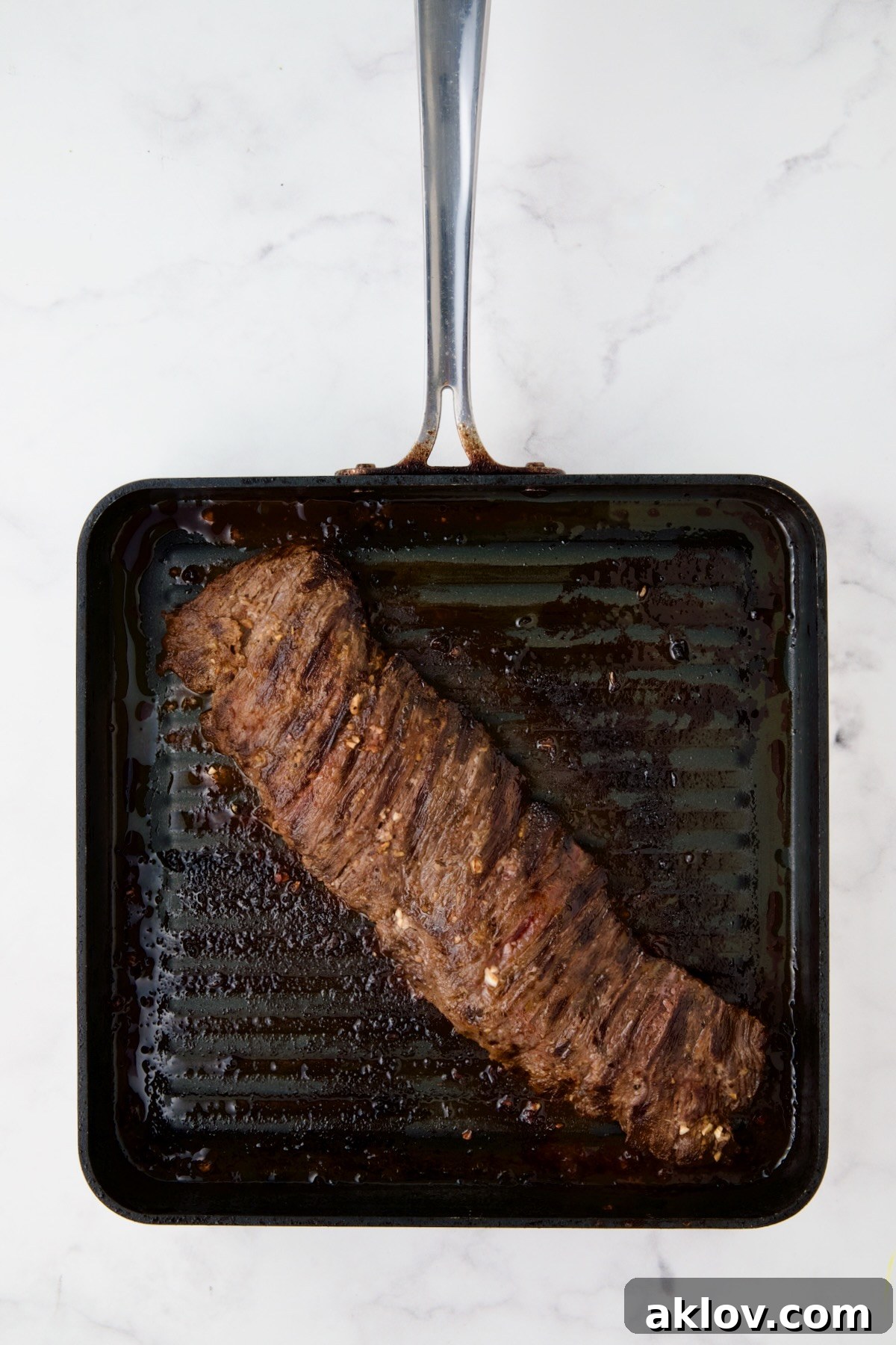 Grilled skirt steak on square grill pan.