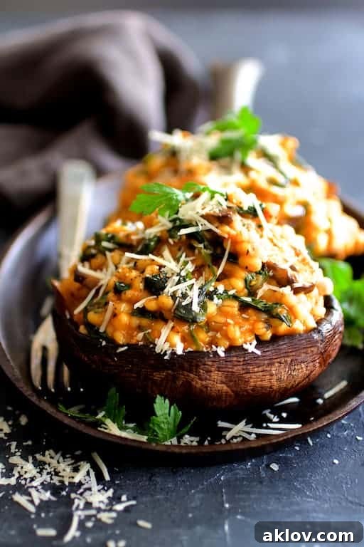 Photo of Barley Risotto Stuffed Portobello Mushrooms on cast iron pan garnished with parsley and Parmesan cheese.