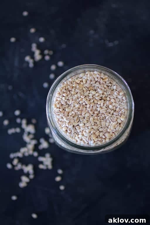 Photo of uncooked pearl barley in a glass jar, ready for cooking.