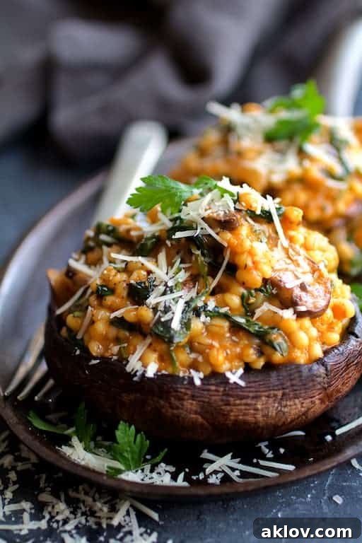 Photo of Barley Risotto Stuffed Portobello Mushrooms garnished with fresh parsley and Parmesan cheese, ready to be served.