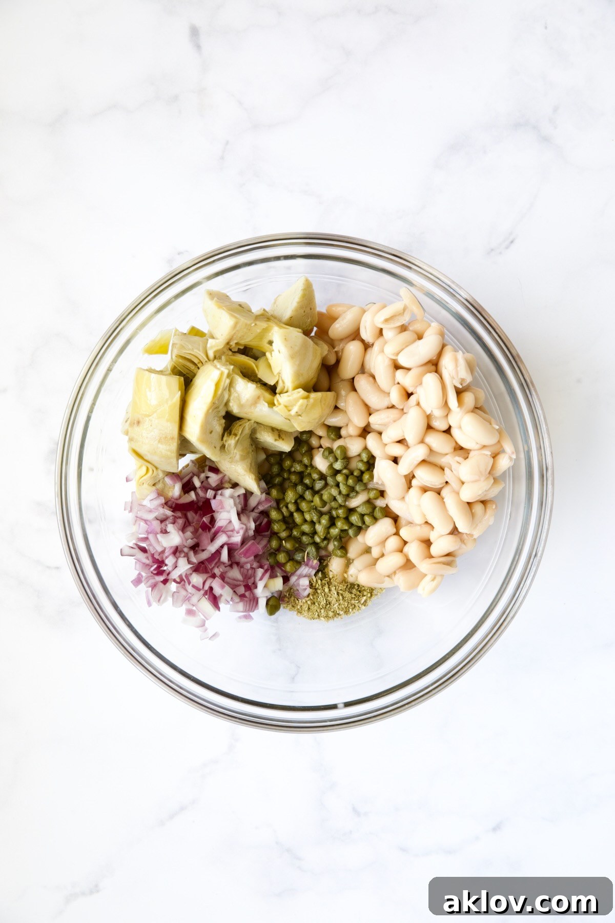 Ingredients for tuna salad in glass bowl before being combined.