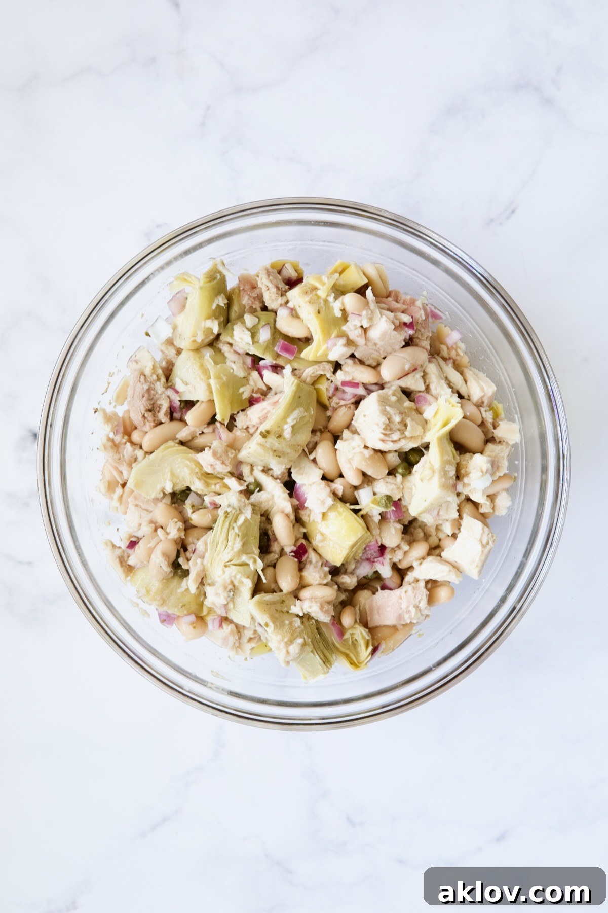 Artichokes, beans and tuna in glass bowl.