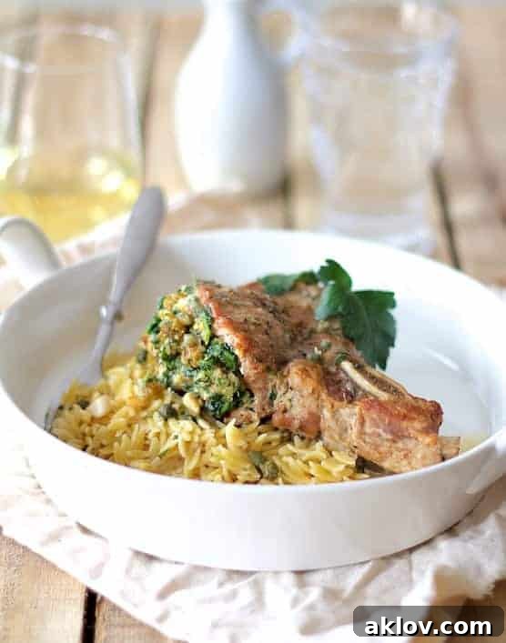Sicilian Stuffed Pork Chops with White Wine Caper Sauce in white dish.
