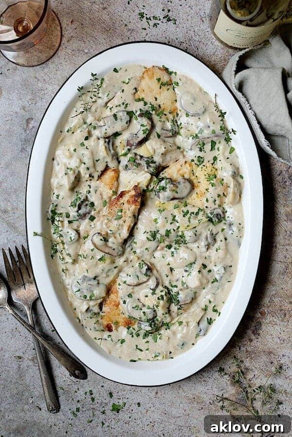 Turkey Scallopini in Sherry Cream Sauce with Mushrooms and Artichokes - Overhead shot of finished dish on white platter
