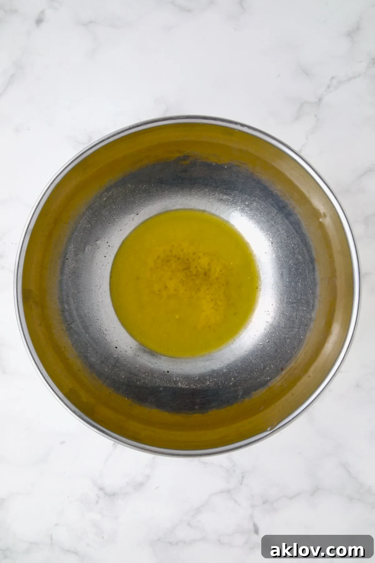 Melted butter in stainless steel bowl.