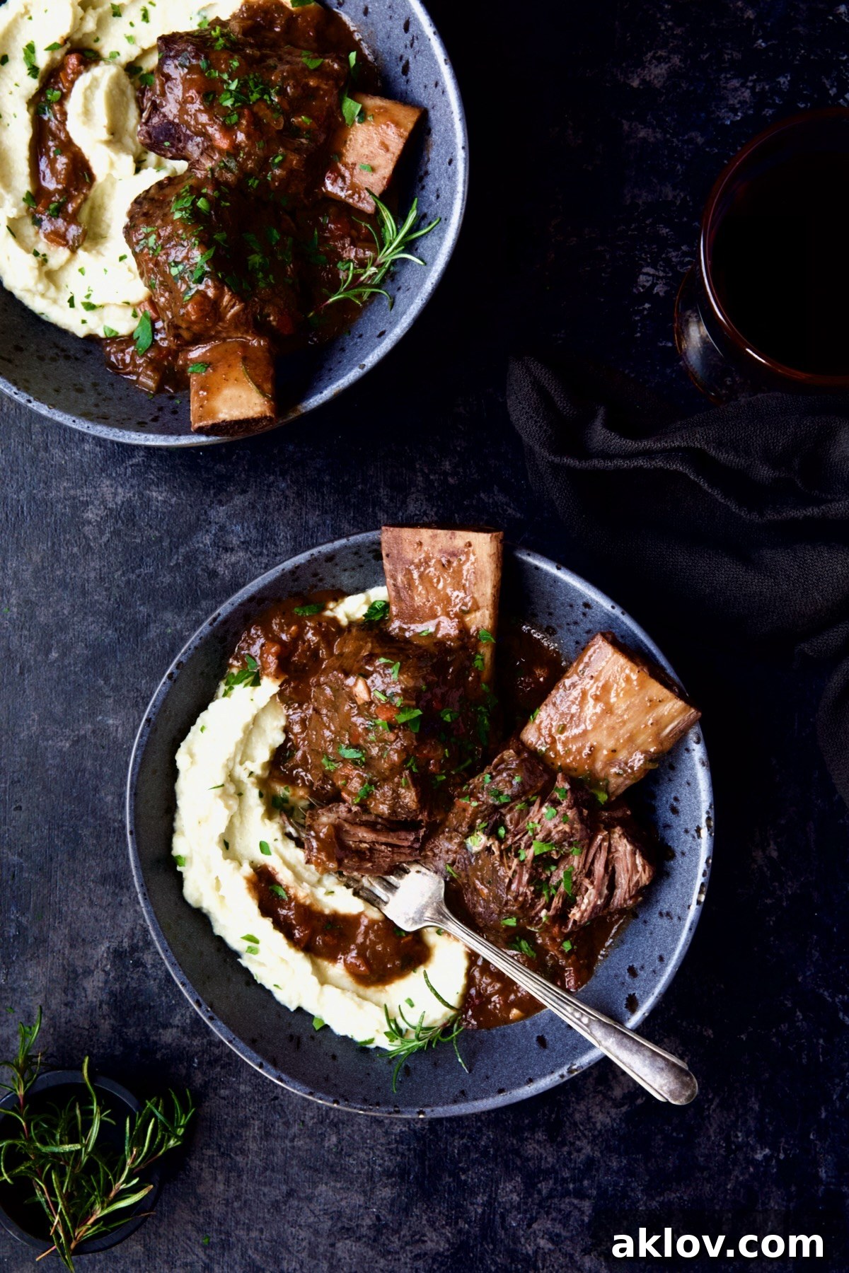 Two bowls of perfectly plated Braised Beef Short Ribs with Cauliflower Leek Puree, ready to be enjoyed.