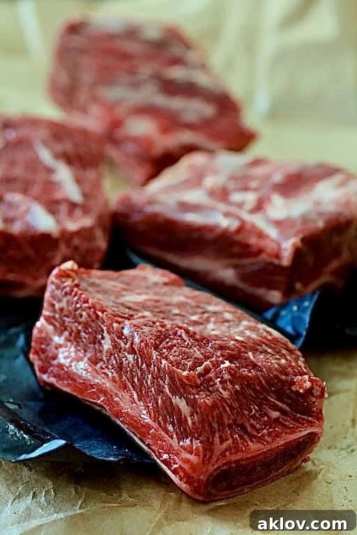 Beef short ribs arranged on butcher paper, showcasing their raw cut.