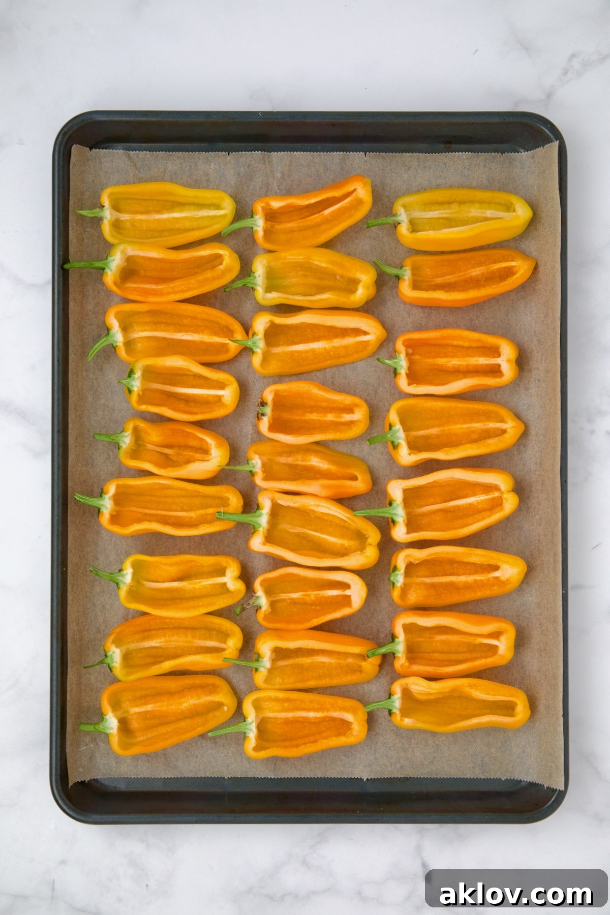 Mini Pepper Taco Poppers 5 Halved yellow mini peppers on parchment paper lined baking sheet.