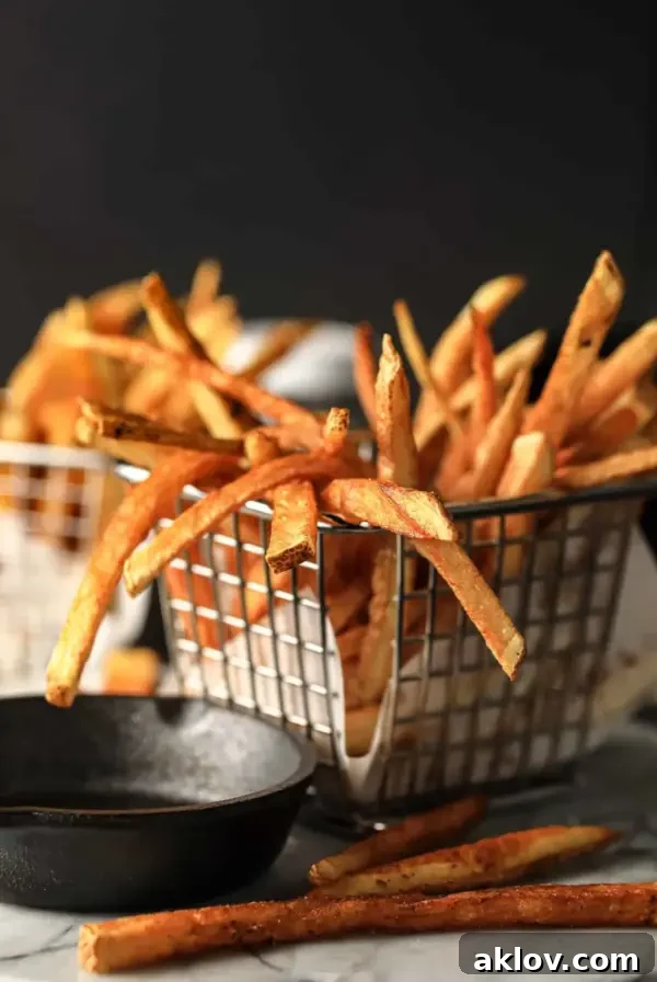 Perfectly golden and crispy French fries in a wire basket, ready to be enjoyed.