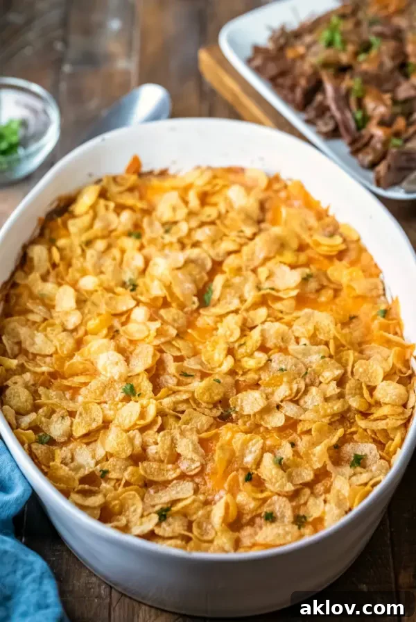 Funeral potatoes in oval white baking dish, a classic comforting casserole.