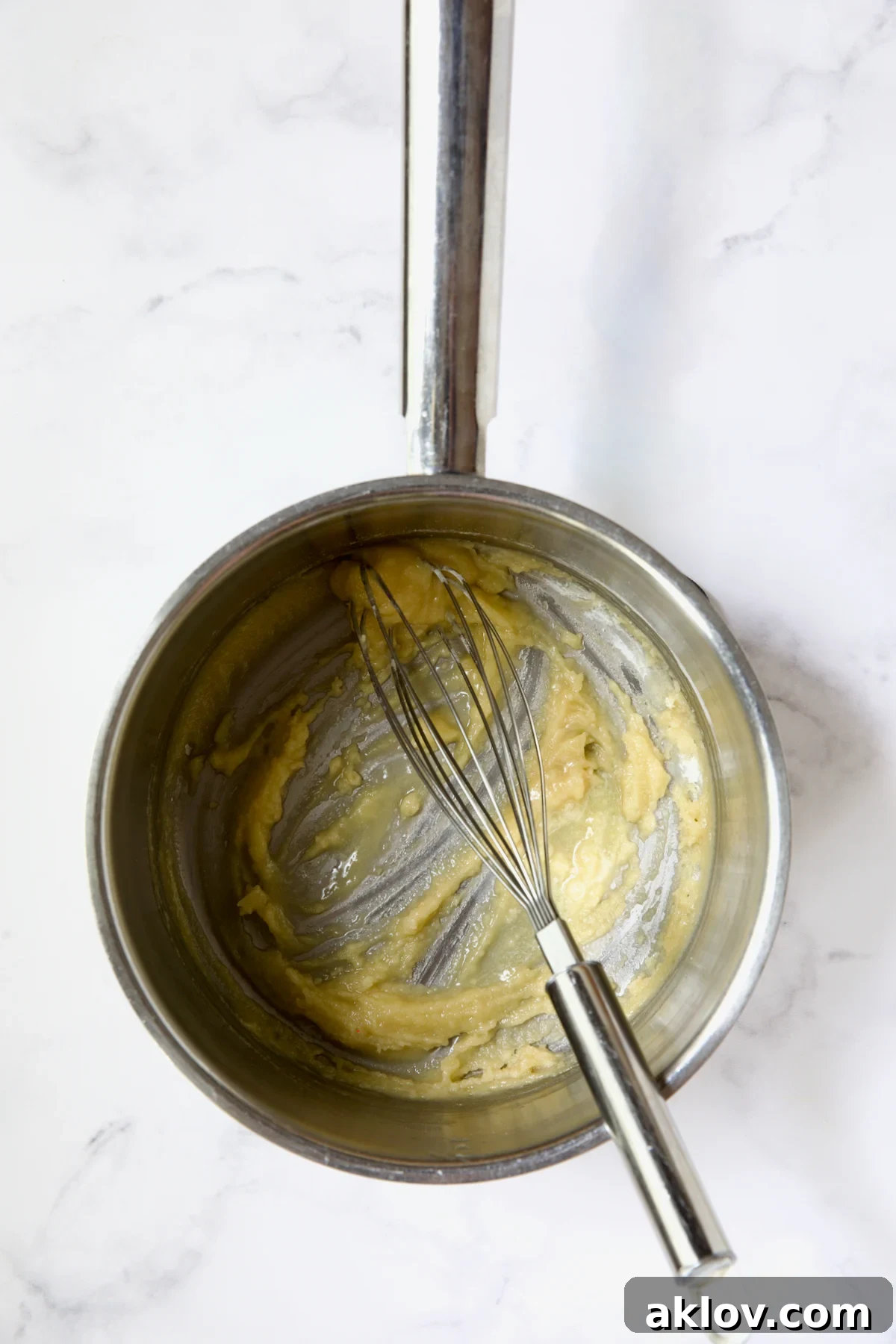Melted butter and flour combined with wire whisk in stainless steel saucepan.