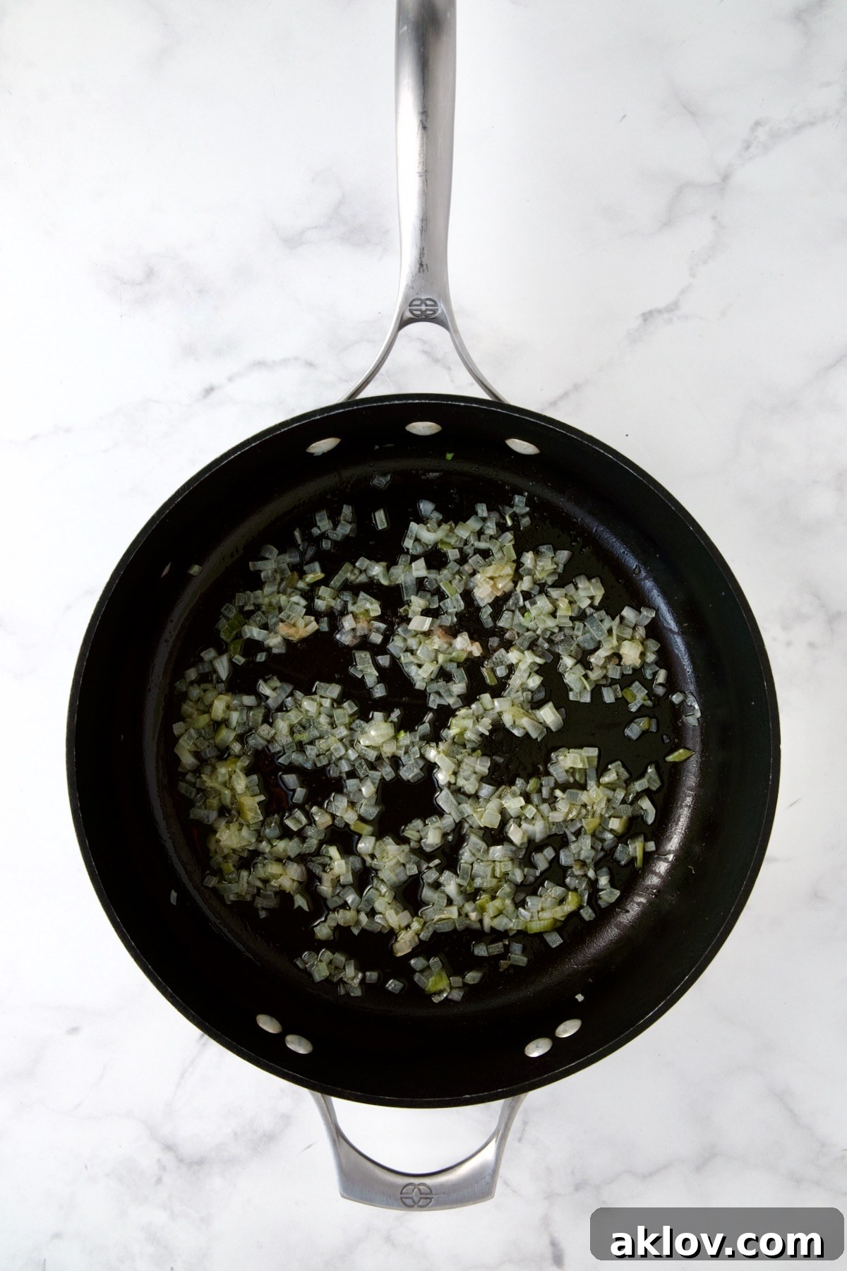 Sautéed shallots sizzling in a nonstick skillet, aromatic and perfectly softened, forming the base for the creamy cabbage casserole.