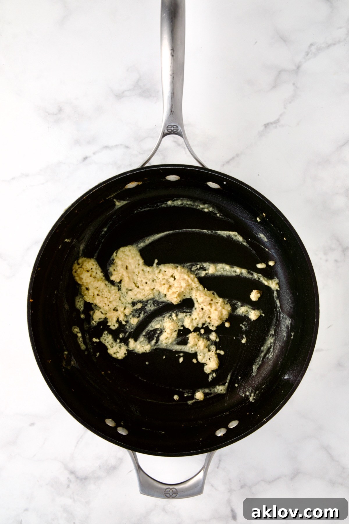 A golden-brown roux, a combination of melted butter and flour, bubbling gently in a nonstick skillet, forming the base for the creamy sauce.