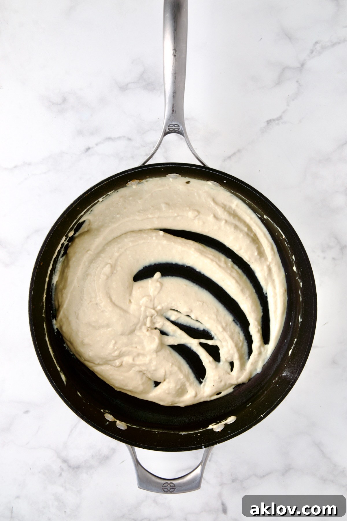 A perfectly thickened creamy sauce in a skillet, enriched with Dijon mustard and Worcestershire sauce, ready to be combined with the cabbage.