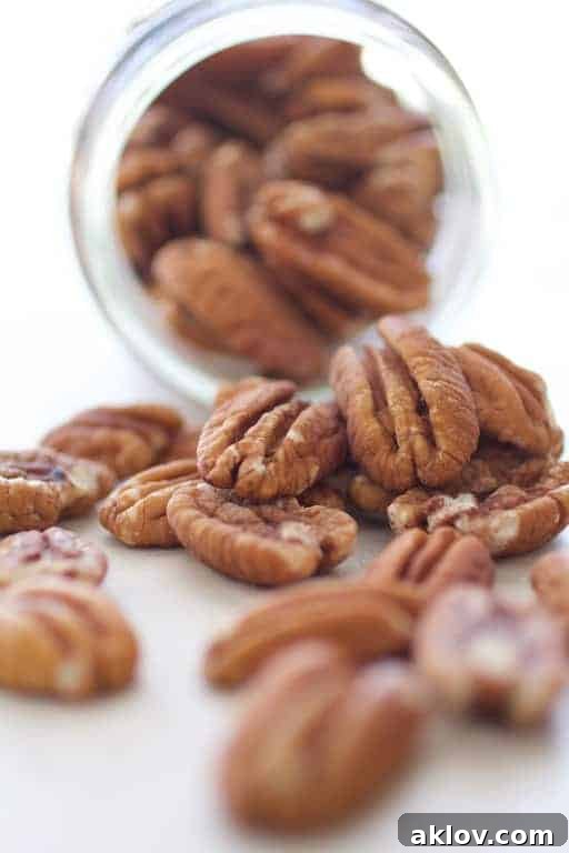 Photo of pecans spilling out of glass jar.