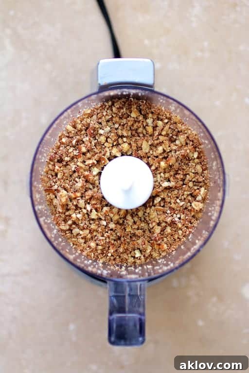 Photo of ground pecans in mini food processor.