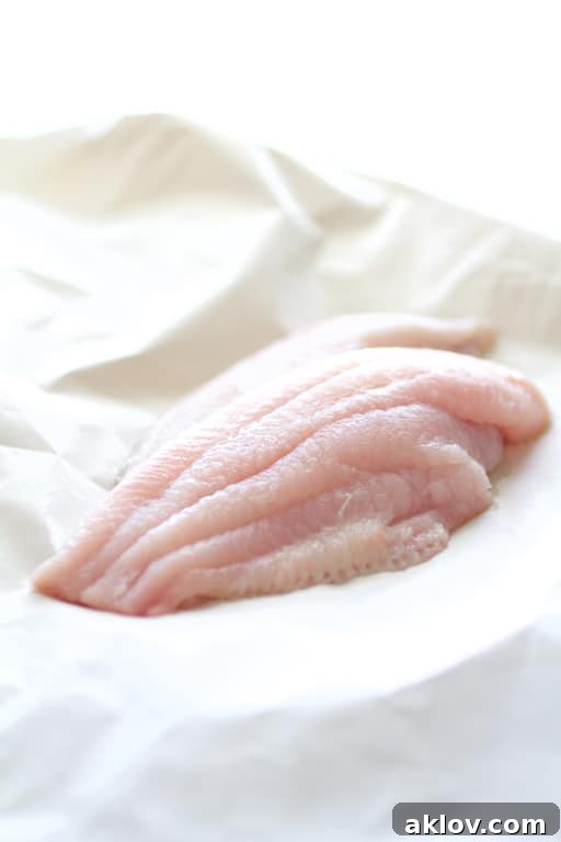 Photo of fresh catfish fillets on white butcher paper before being coated and baked.