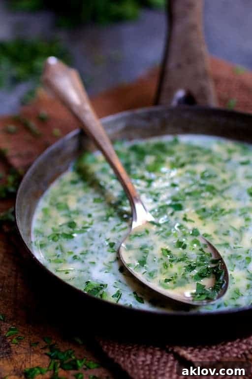 Photo of melted butter in small saucepan with some on a spoon.