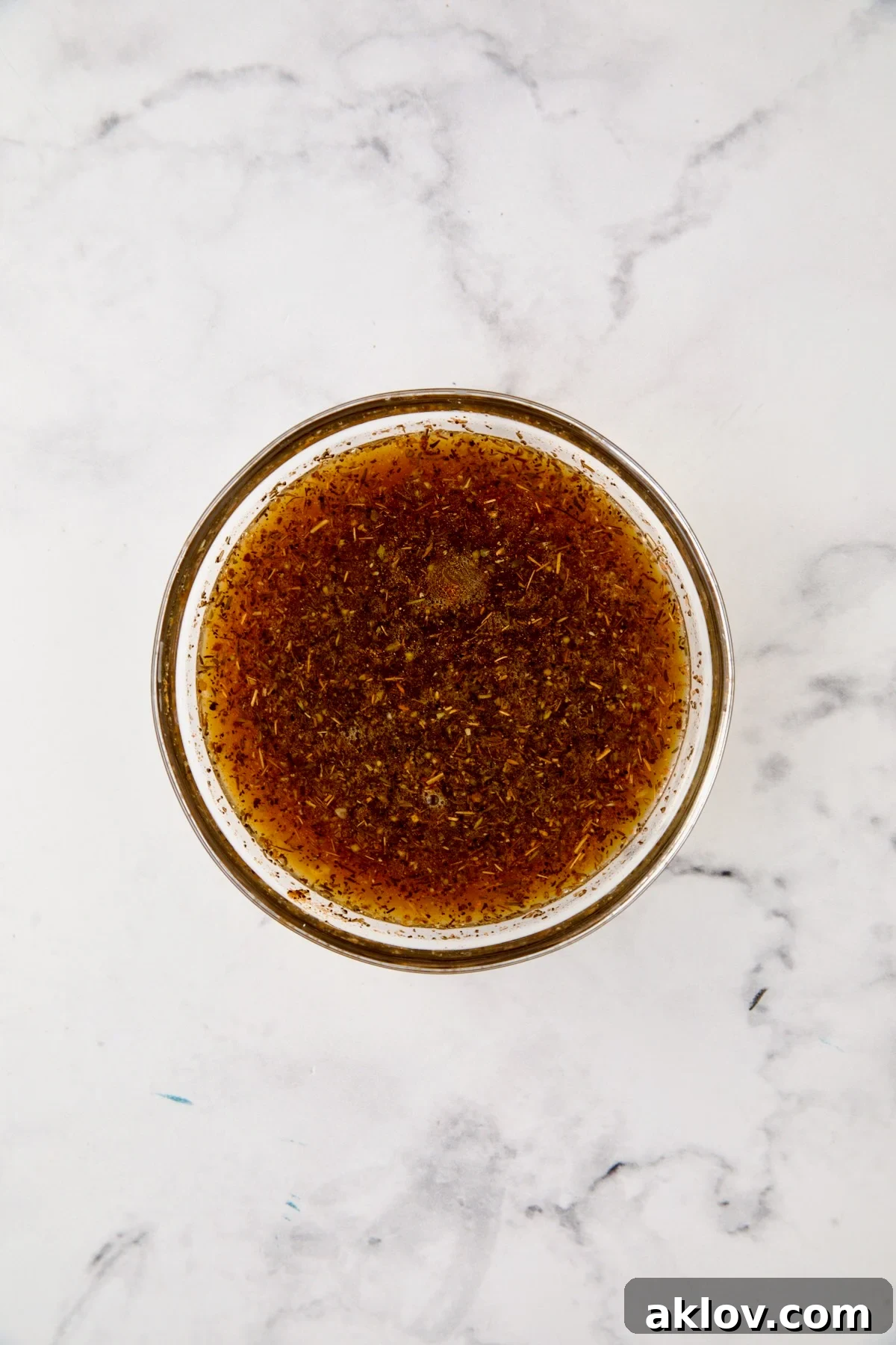 Herb and broth blend in glass bowl.
