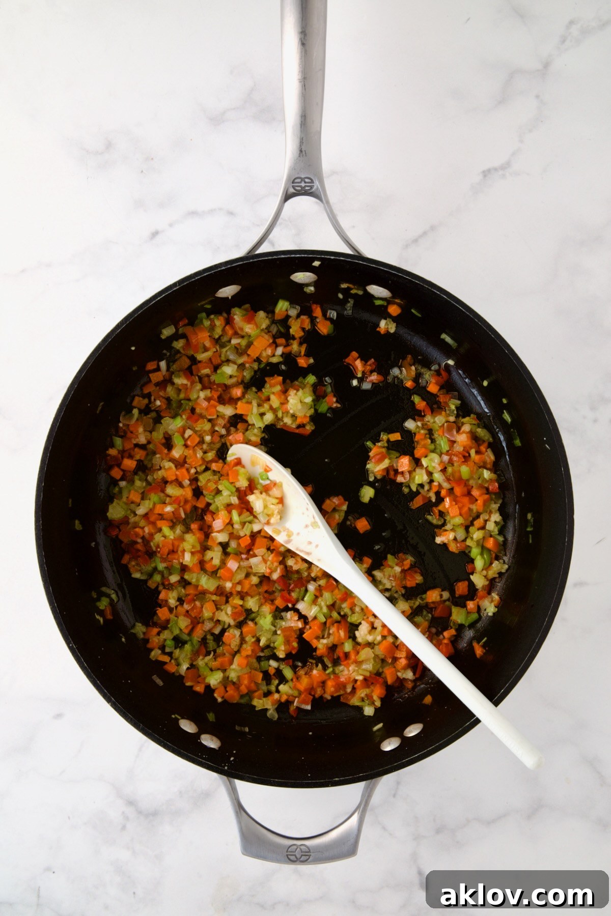 Sautéed celery, carrots, red bell pepper, and scallions glistening in a nonstick skillet.